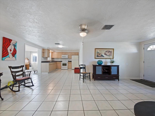interior space featuring a textured ceiling, visible vents, light tile patterned floors, and a ceiling fan
