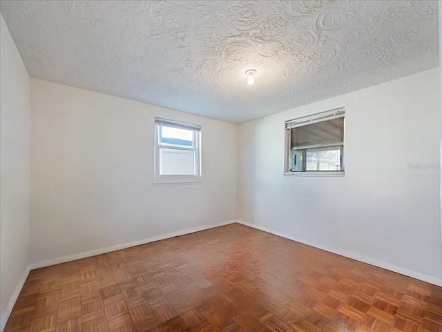 unfurnished room featuring baseboards and a textured ceiling