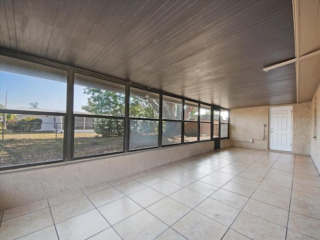 unfurnished sunroom featuring tile patterned flooring and wooden ceiling