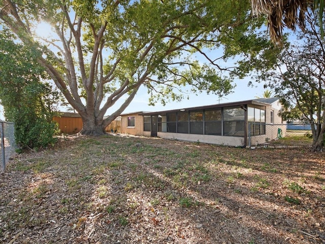 view of yard featuring a fenced backyard and a sunroom