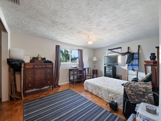 bedroom with baseboards, visible vents, and a textured ceiling