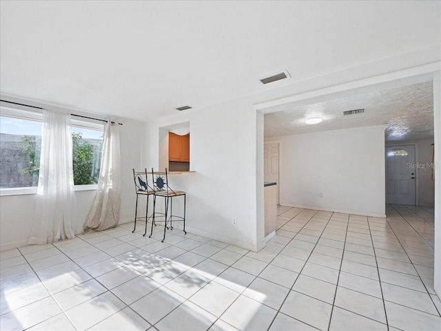 empty room with light tile patterned floors and visible vents