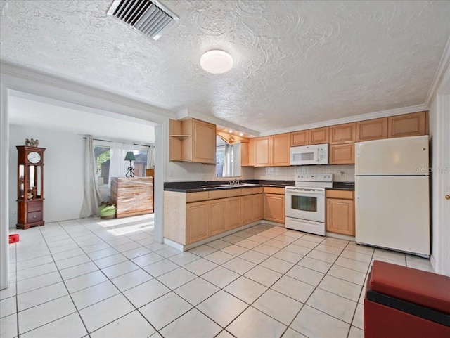 kitchen featuring dark countertops, visible vents, a wealth of natural light, and white appliances