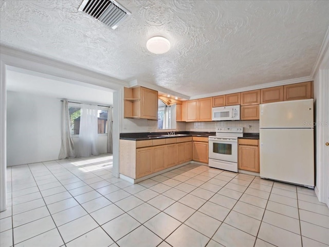 kitchen featuring a healthy amount of sunlight, visible vents, white appliances, and dark countertops