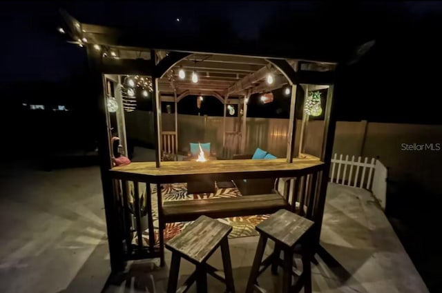 patio at twilight featuring fence