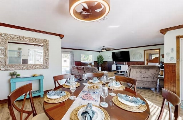 dining area featuring wainscoting, a ceiling fan, wood finished floors, and crown molding