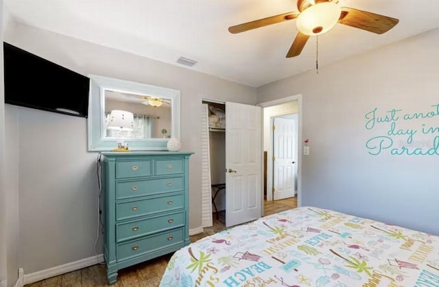 bedroom featuring baseboards, a ceiling fan, visible vents, and dark wood-style flooring