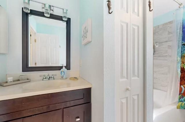 full bathroom with a closet, vanity, and shower / bathtub combination with curtain