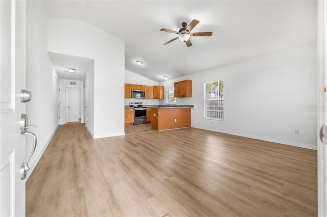 unfurnished living room featuring lofted ceiling, light wood finished floors, a ceiling fan, a sink, and baseboards