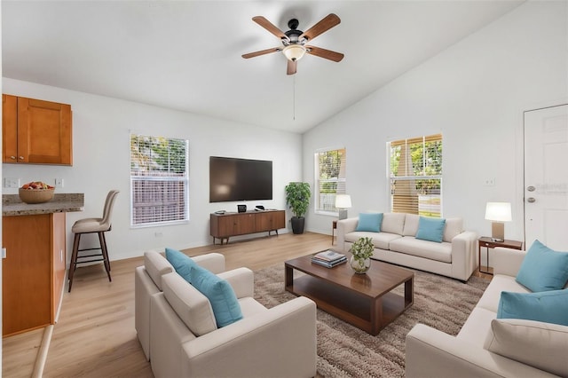 living area featuring light wood finished floors, high vaulted ceiling, and ceiling fan