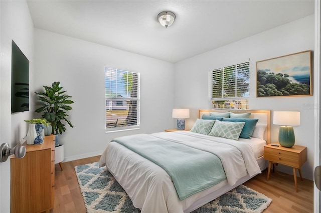 bedroom with light wood-style flooring and baseboards