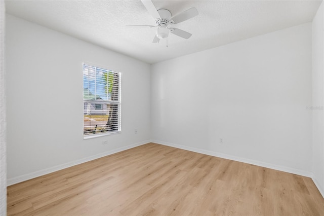 unfurnished room with light wood-type flooring, a textured ceiling, a ceiling fan, and baseboards