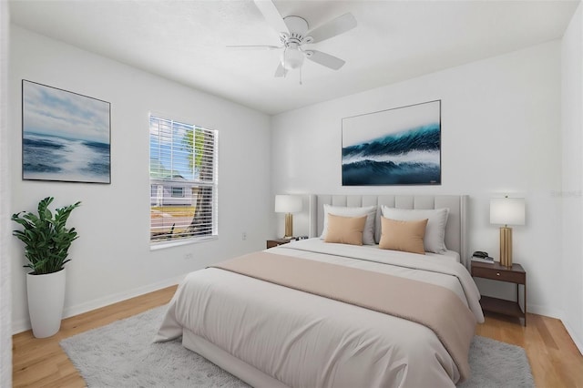 bedroom featuring light wood-type flooring, baseboards, and ceiling fan