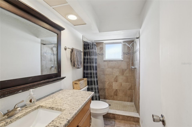 full bath with vanity, tile patterned floors, a tile shower, and toilet