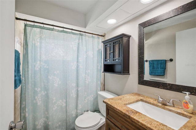 bathroom with vanity, curtained shower, and toilet