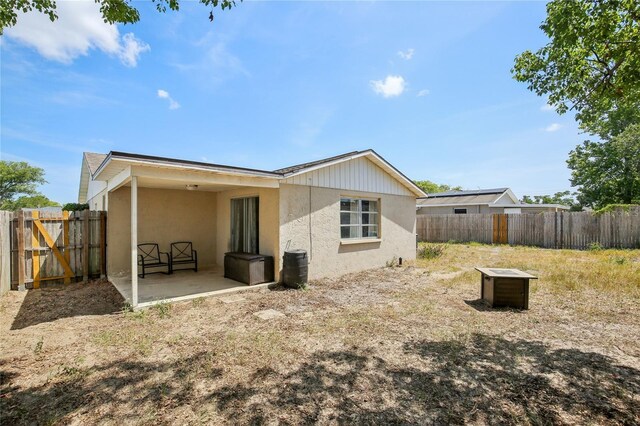 back of property featuring a fenced backyard, a patio, and stucco siding