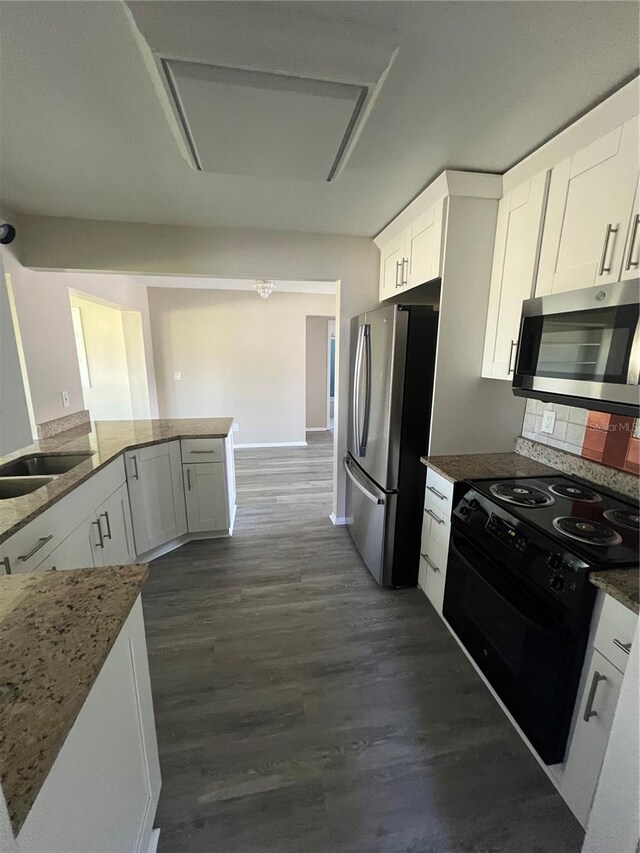 9825 41st St N, Pinellas Park, FL 33782 - kitchen featuring dark stone counters, white cabinetry, a sink, dark wood finished floors, and appliances with stainless steel finishes