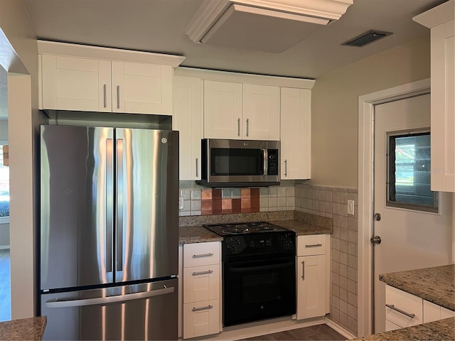 9825 41st St N Unit 9825, Pinellas Park, FL 33782 - kitchen with visible vents, tile walls, white cabinets, dark stone countertops, and stainless steel appliances