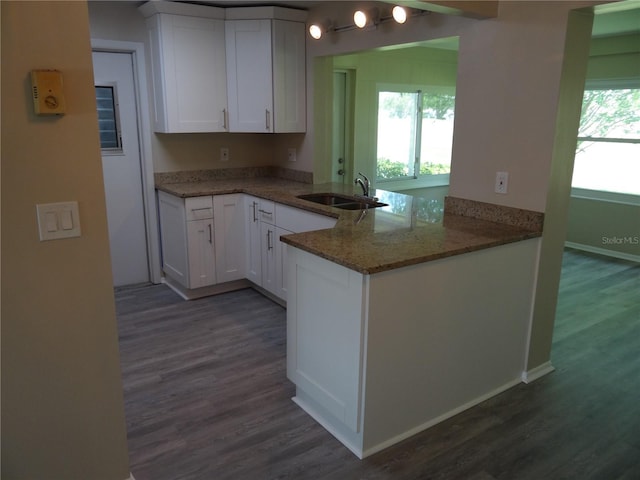9825 41st St N Unit 9825, Pinellas Park, FL 33782 - kitchen featuring dark wood-style flooring, light stone counters, a sink, white cabinetry, and a peninsula