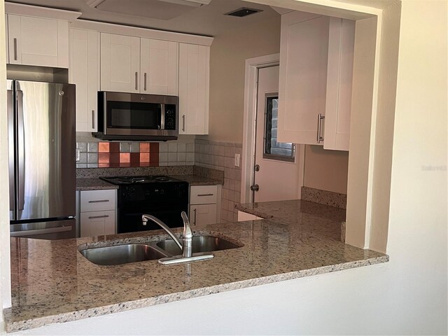 9825 41st St N, Pinellas Park, FL 33782 - kitchen with light stone counters, a sink, appliances with stainless steel finishes, and visible vents