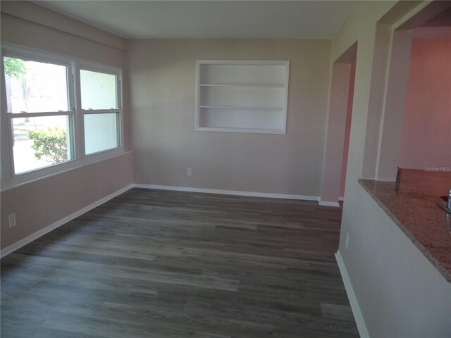 9825 41st St N, Pinellas Park, FL 33782 - empty room featuring baseboards, wood finished floors, and built in shelves