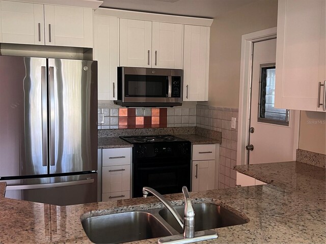 9825 41st St N, Pinellas Park, FL 33782 - kitchen featuring light stone counters, a sink, appliances with stainless steel finishes, and white cabinets