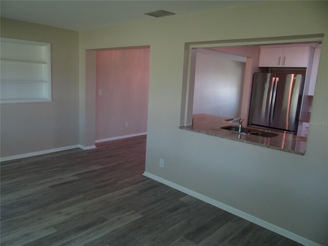 9825 41st St N, Pinellas Park, FL 33782 - empty room with visible vents, dark wood finished floors, built in shelves, a sink, and baseboards