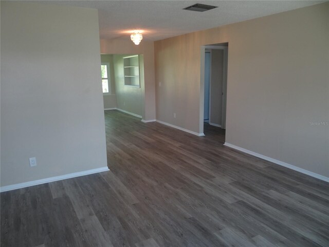9825 41st St N, Pinellas Park, FL 33782 - empty room with visible vents, baseboards, and dark wood finished floors