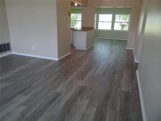 9825 41st St N Unit 9825, Pinellas Park, FL 33782 - unfurnished living room with visible vents, baseboards, and dark wood-type flooring