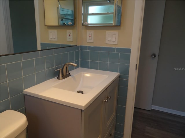 9825 41st St N Unit 9825, Pinellas Park, FL 33782 - bathroom featuring vanity, wood finished floors, toilet, tile walls, and a wainscoted wall