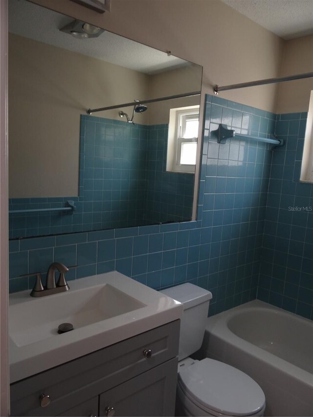 9825 41st St N, Pinellas Park, FL 33782 - bathroom featuring shower / bathtub combination, toilet, tile walls, and vanity
