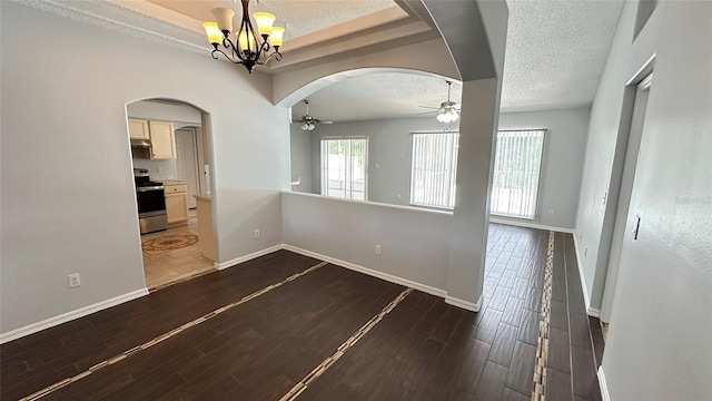 28818 Midnight Star Loop, Wesley Chapel, FL 33543 - unfurnished dining area featuring arched walkways, a ceiling fan, a chandelier, a textured ceiling, and a raised ceiling