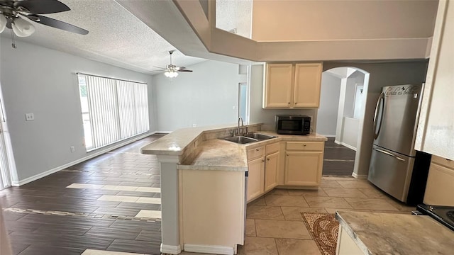 28818 Midnight Star Loop, Wesley Chapel, FL 33543 - kitchen featuring black microwave, a sink, freestanding refrigerator, ceiling fan, and arched walkways