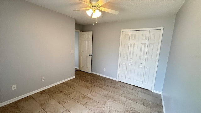 28818 Midnight Star Loop, Wesley Chapel, FL 33543 - unfurnished bedroom featuring baseboards, a closet, a ceiling fan, and a textured ceiling