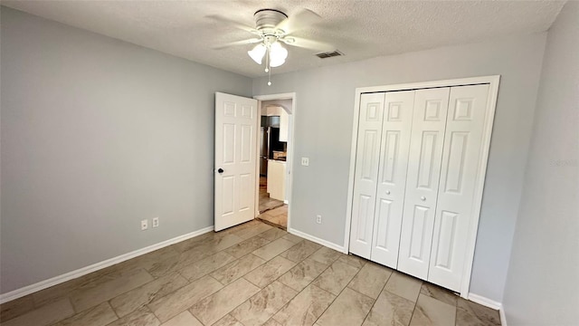 28818 Midnight Star Loop, Wesley Chapel, FL 33543 - unfurnished bedroom with baseboards, a closet, a textured ceiling, and a ceiling fan