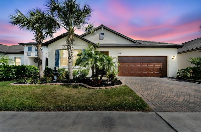 view of front of house featuring a garage, stucco siding, and decorative driveway