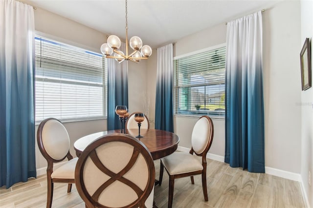 dining room with light wood-type flooring, baseboards, and a chandelier