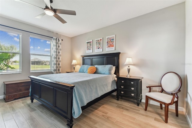 bedroom featuring baseboards, a ceiling fan, and light wood finished floors