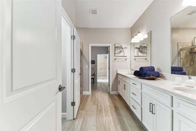 full bath featuring double vanity, visible vents, and a sink