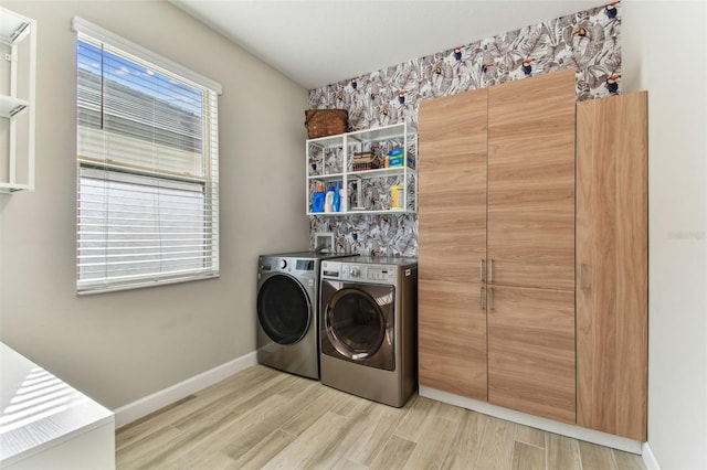 laundry room featuring washing machine and dryer, baseboards, laundry area, and light wood-type flooring
