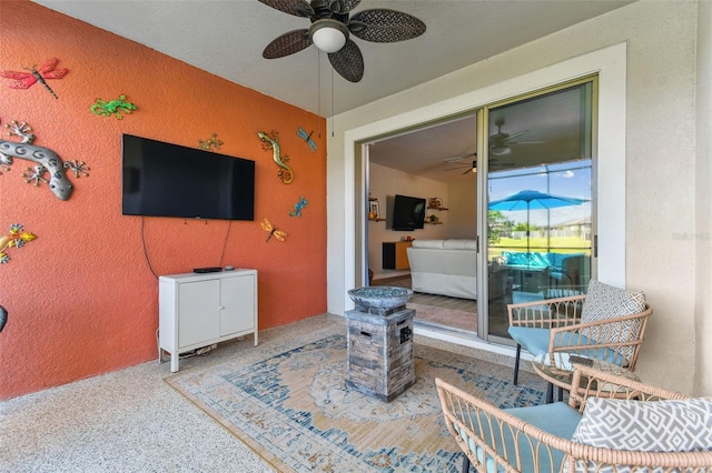 exterior space with a textured wall and ceiling fan