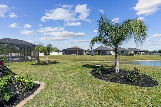 view of yard with a lanai and a water view