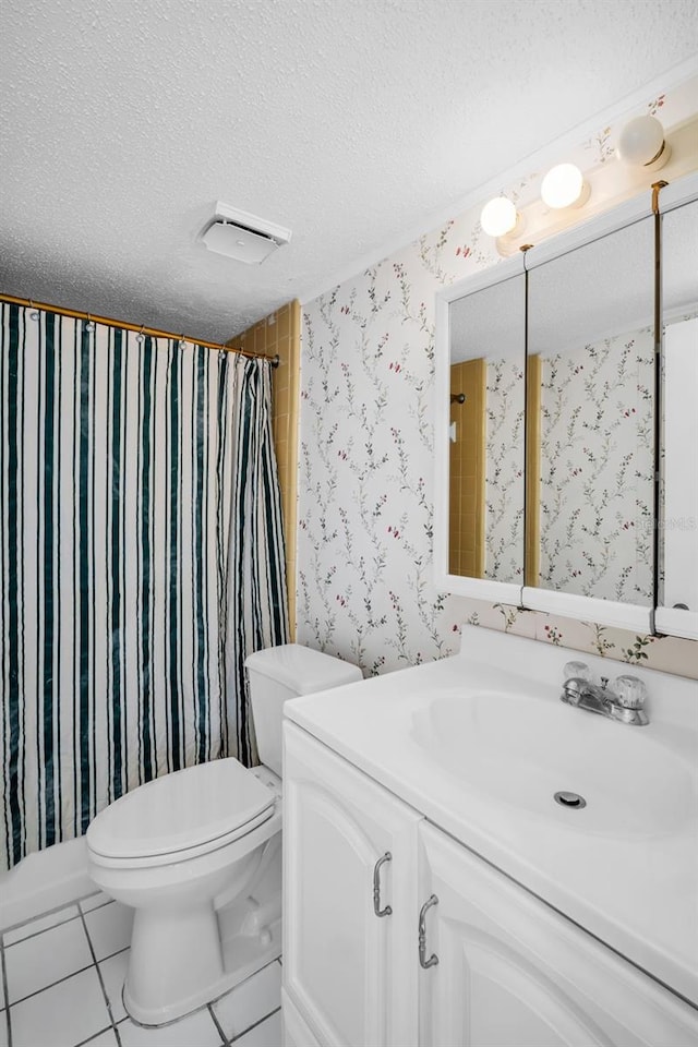 bathroom with wallpapered walls, a textured ceiling, toilet, tile patterned flooring, and vanity