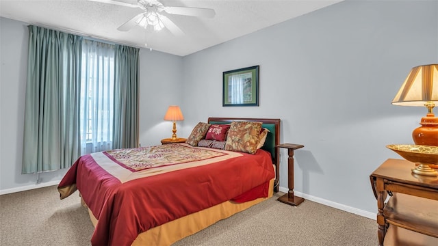 bedroom featuring carpet floors, baseboards, a textured ceiling, and a ceiling fan