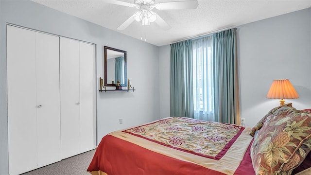 carpeted bedroom with a textured ceiling, a closet, and a ceiling fan