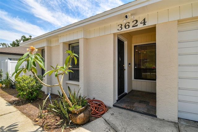 doorway to property with fence and stucco siding