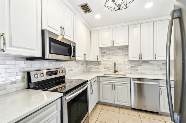 kitchen featuring stainless steel appliances, light tile patterned floors, a sink, white cabinetry, and visible vents
