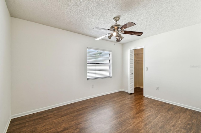unfurnished room featuring baseboards, wood finished floors, a ceiling fan, and a textured ceiling