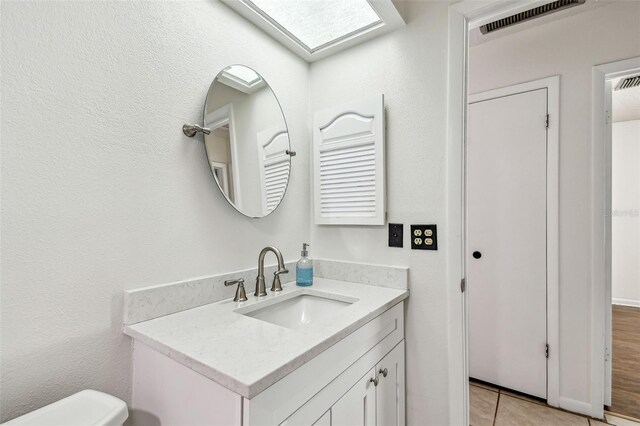 bathroom featuring tile patterned floors, toilet, visible vents, and vanity