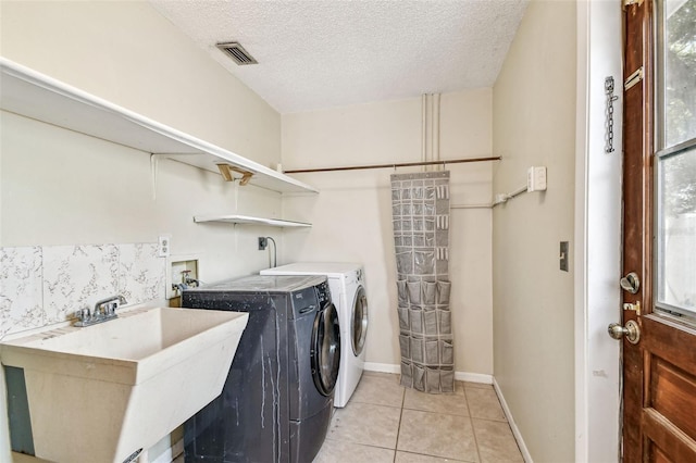 laundry room with independent washer and dryer, a sink, visible vents, light tile patterned flooring, and laundry area